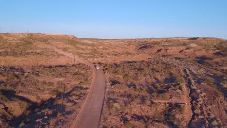 aerial view of off road car in a dirt road on a desertic, dry, rocky, sand
landscape