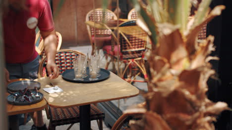 waiter clearing table at restaurant, face unseen