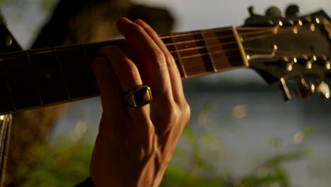 person playing acoustic guitar outdoors