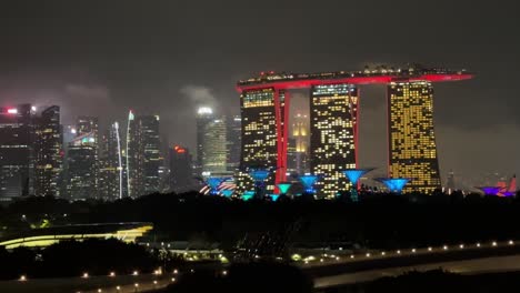 Imágenes-Nocturnas-Del-Puerto-De-Singapur-Que-Muestran-Las-Arenas-De-Marina-Bay,-Jardines-Junto-A-La-Bahía-Y-árboles-Con-Forma-De-Avatar,-Con-El-Horizonte-De-Singapur-A-La-Izquierda.