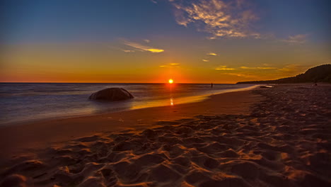 puesta de sol de arena y mar ondulada con colores azules y amarillos y una ráfaga de sol