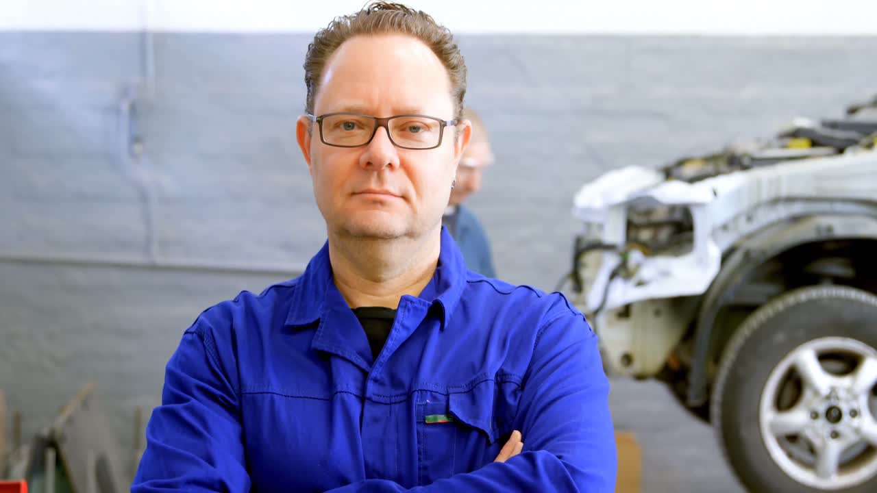 mecánico mirando a la cámara en el garaje 4k