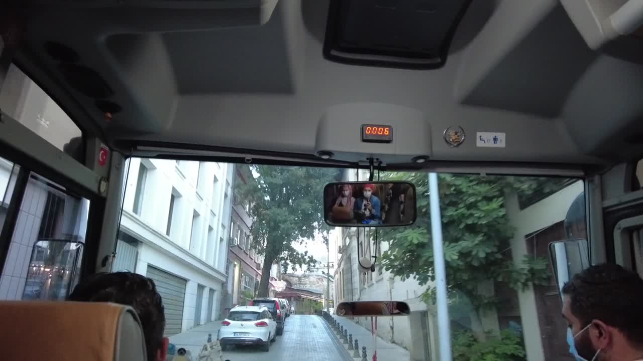 Front view from a traveling tour bus navigating the narrow streets of Istanbul, Turkey. A dynamic journey through the city's charming alleys, showcasing the blend of old and new urban life.