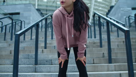 Closeup-female-legs-running-down-stairs.-Tired-girl-wiping-sweat-on-city-street