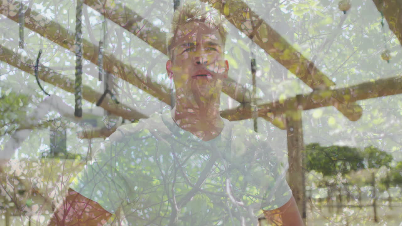 Standing outdoors, man with tree branches and leaves creating animation effect