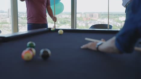 compañeros de oficina anónimos jugando al billar en el edificio de oficinas de coworking durante la hora del almuerzo