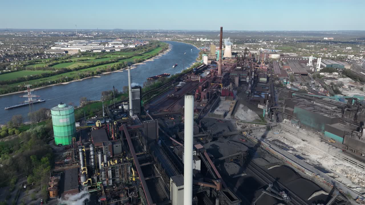 Cokes factory along the rhine river. Industrial production in Germany. Metal industrial chimney. Aerial view.