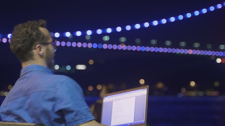 Businessman rejoice. Illuminated seaside at night.