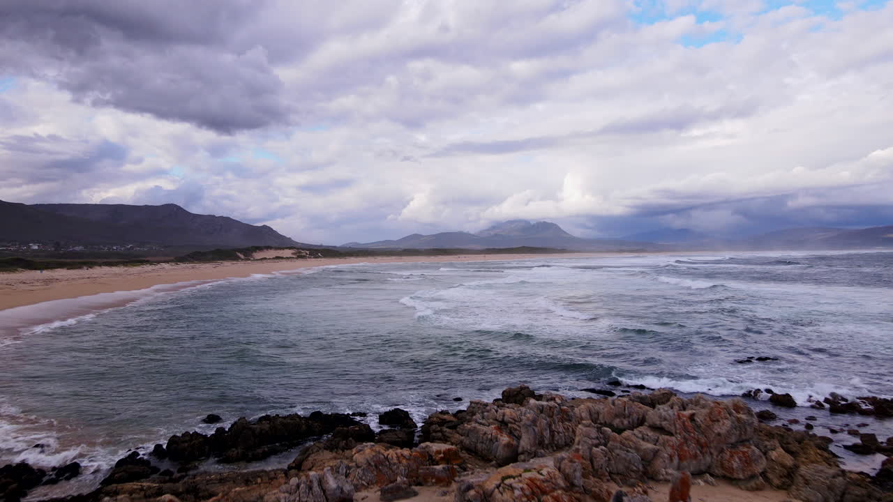 dolly aéreo hacia la pintoresca playa de bandera azul de kleinmond con el río bot adyacente