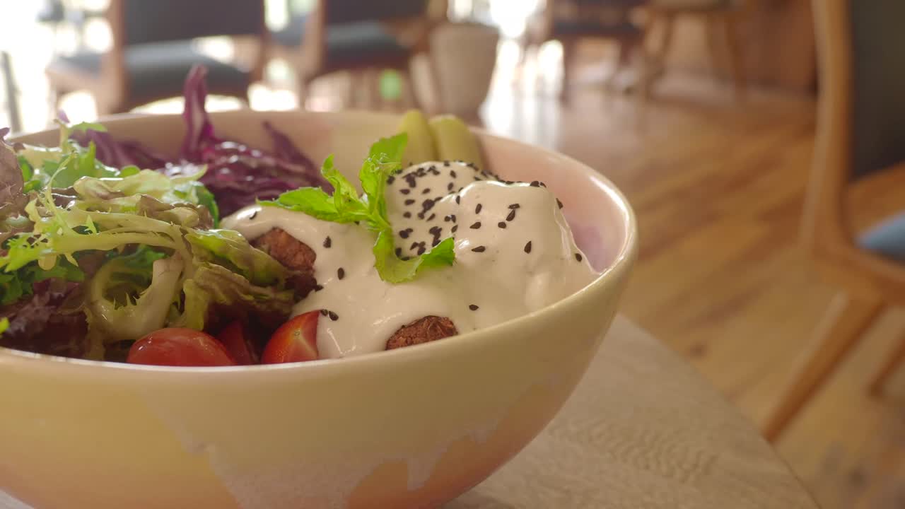 Bowl of salad with falafel and vegetables