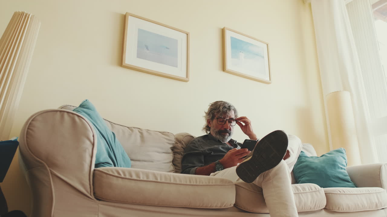 Man using smartphone on couch