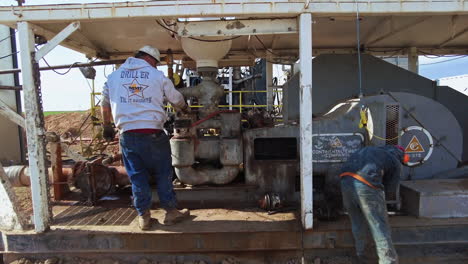 men work at the equipment for drilling natural resources. oil production industry in the desert.