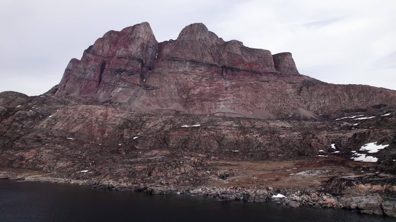 Epic drone dolly shot of Uummannaq mountain, revealing the scale of the peak
