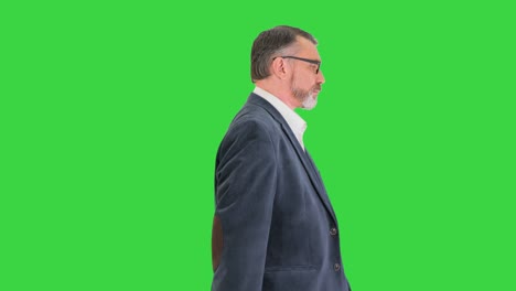 senior business man walking forward on a green screen, chroma key