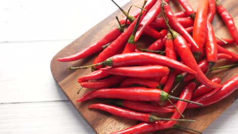 una pila de pimientos rojos en una tabla de cortar de madera