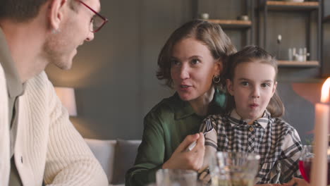 happy family sitting at table and having a meal at home