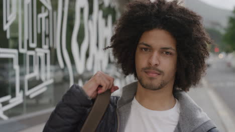 portrait of young man smiling looking at camera happy male student enjoying successful  college lifestyle in urban city street background