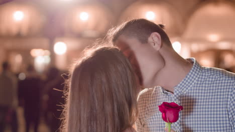 una pareja compartiendo un momento romántico con una rosa