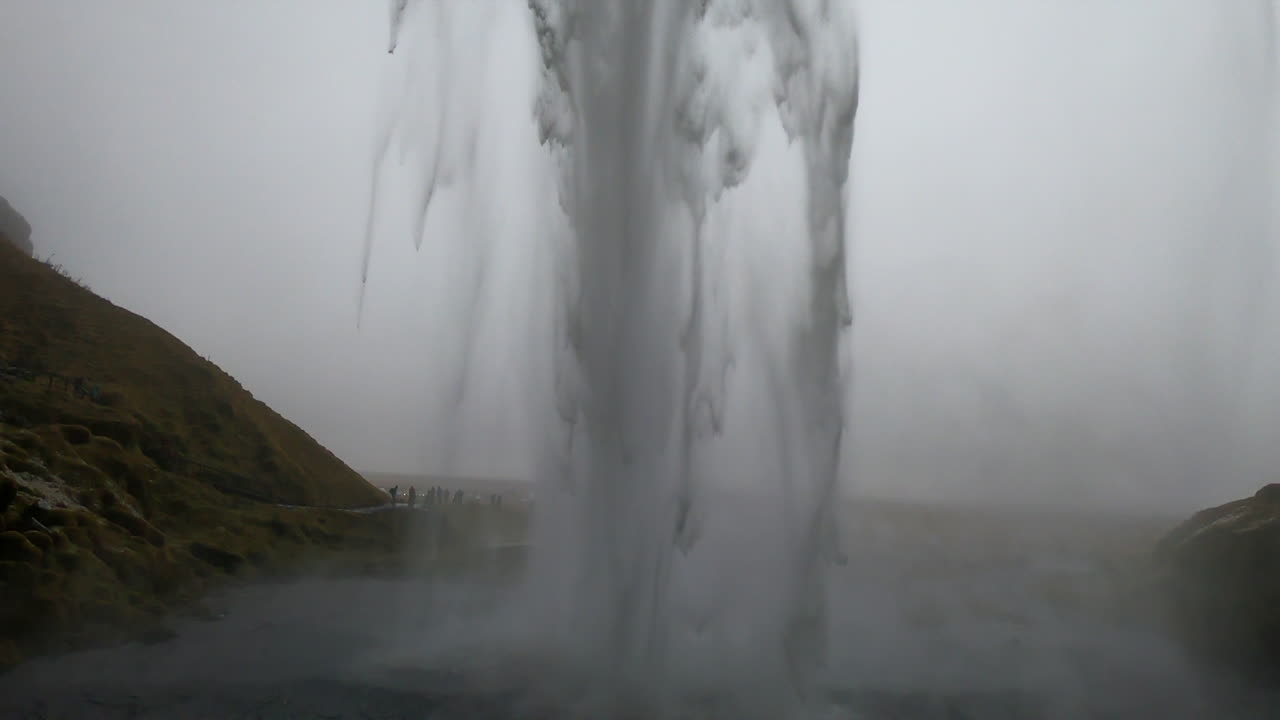 아이슬란드의 셀야란드스포스(seljalandsfoss) 폭포 뒤에서 물이 힘차게 부서지는 장면