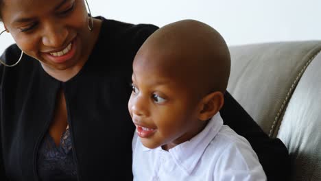 Mother-and-son-using-laptop-on-the-sofa-in-a-comfortable-home-4k