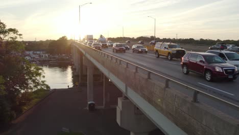 Aufsteigende-Drohne-Schoss-Zur-Hauptverkehrszeit-über-Die-Autobahn,-Starker-Verkehr-Auf-Der-Brücke,-Zur-Goldenen-Stunde