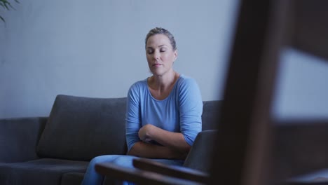 Tired-caucasian-woman-sitting-on-sofa-in-hospital-waiting-room