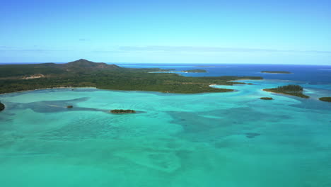 Establishing-aerial-over-scenic-Baie-de-la-Corbeille,-or-Bay-of-the-Basket,-Isle-of-Pines