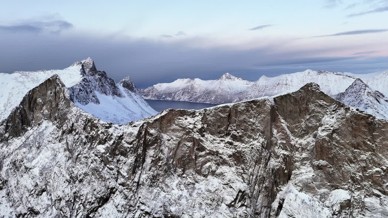 Cinematic aerial view of Hesten, one of the most photographed peaks on Senja Island, Norway, its horse-like shape towering over fjords and rugged Arctic landscapes in Troms og Finnmark County