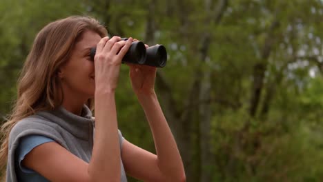 smiling woman using binoculars