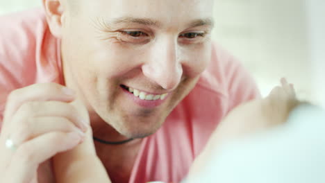 cara feliz de un joven padre admiración y con una sonrisa mirando a su bebécara feliz de un joven fa