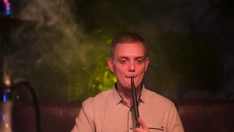 man smoking hookah in a lounge