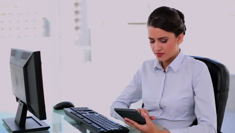 confused beautiful businesswoman using a calculator