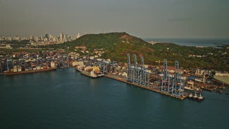 panama city aerial v47 cinematic tracking shot capturing cargo ship and car carrier docked at the harbor of port balboa with ancon hill and cityscape background - shot with mavic 3 cine - march 2022