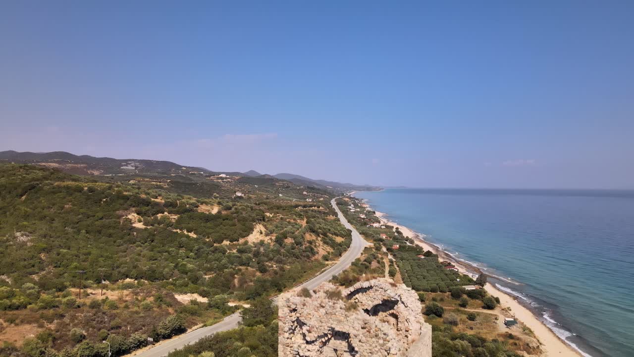 clip aéreo de drones que asciende sobre una antigua torre en ruinas y una playa en kavala, macedonia, grecia