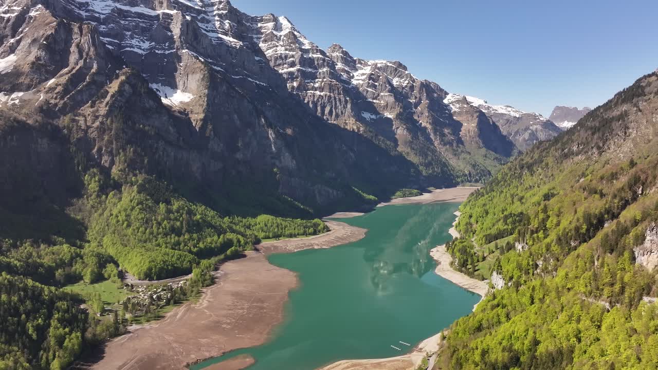 Aerial view of Klöntalersee surrounded by alpine mountains and forests in Glarus, Switzerland