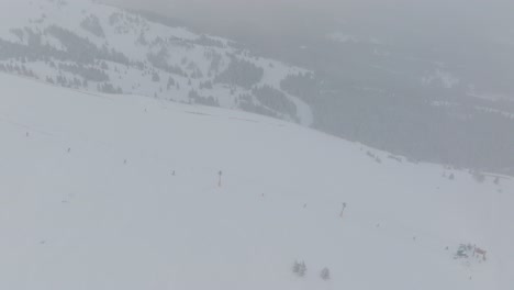 aerial top shot of snow boarders snowboarding on copper mountain on a foggy morning in colorado, usa.
