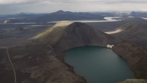 Tiro-De-Empuje-Ascendente-Del-Lago-Del-Cráter-Rodeado-De-Paisaje-Volcánico-Durante-Las-Nubes-En-El-Cielo