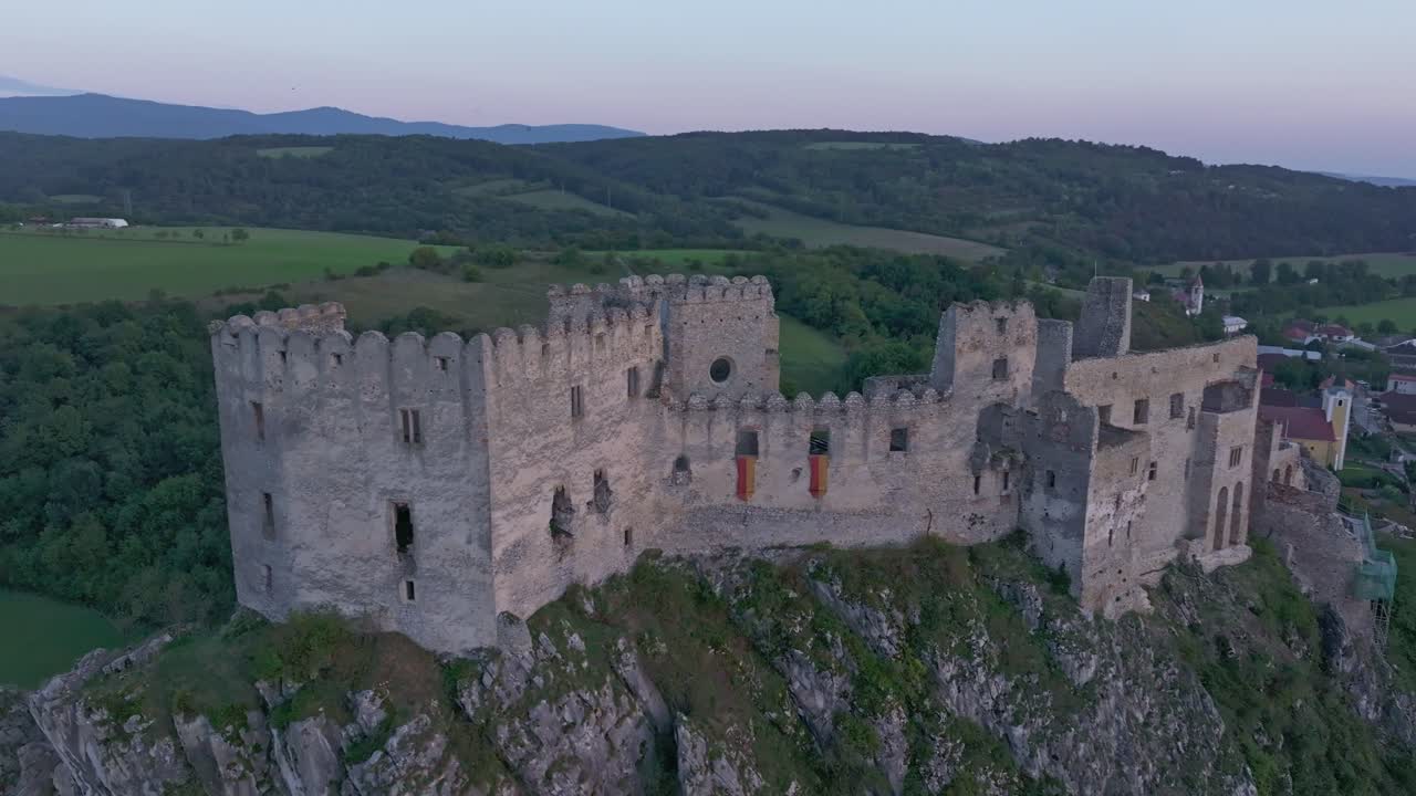 Scena dal drone del Castello di Beckov che risplende sotto i caldi toni del tramonto