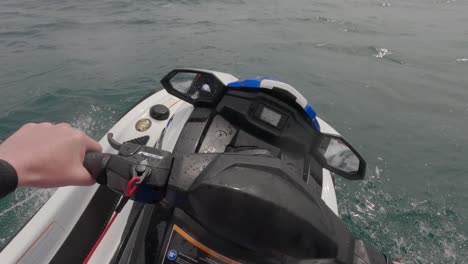 pov shot di un pilota di jet ski che scende dallo sci nell'oceano ad alta velocità