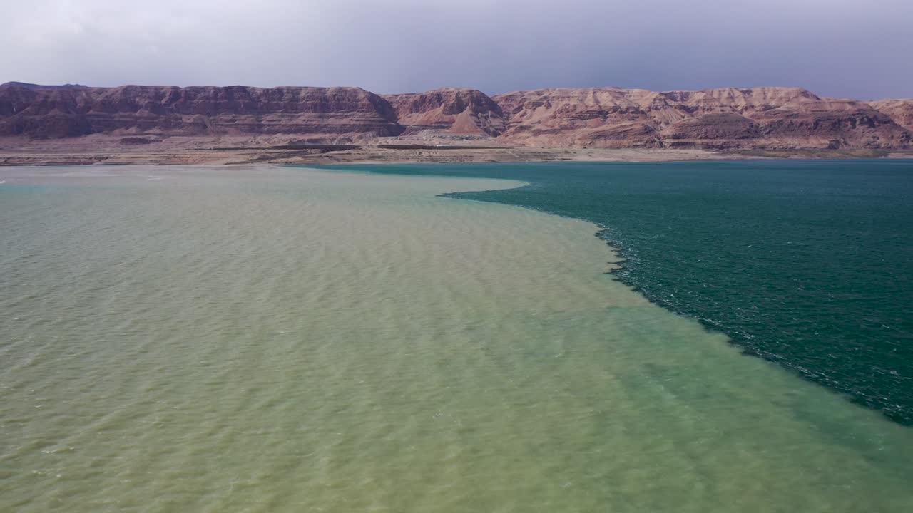 molta acqua fangosa dall'alluvione incontra l'acqua del mar morto, sorvola l'acqua fangosa