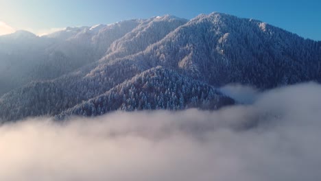 Bezaubernde-Winterdrohne:-Schneebedeckter-Gipfel,-Ziehende-Wolken,-Heitere-Schönheit
