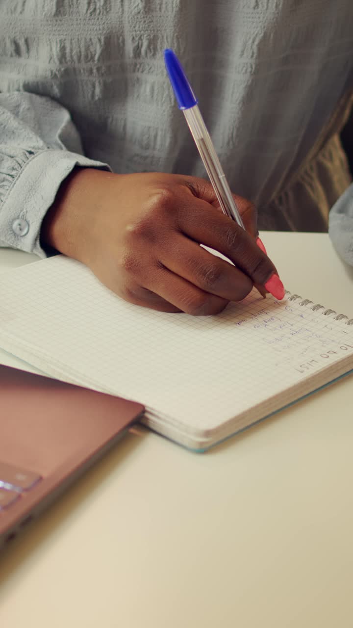 Vertical Blogger writing story ideas on notebook