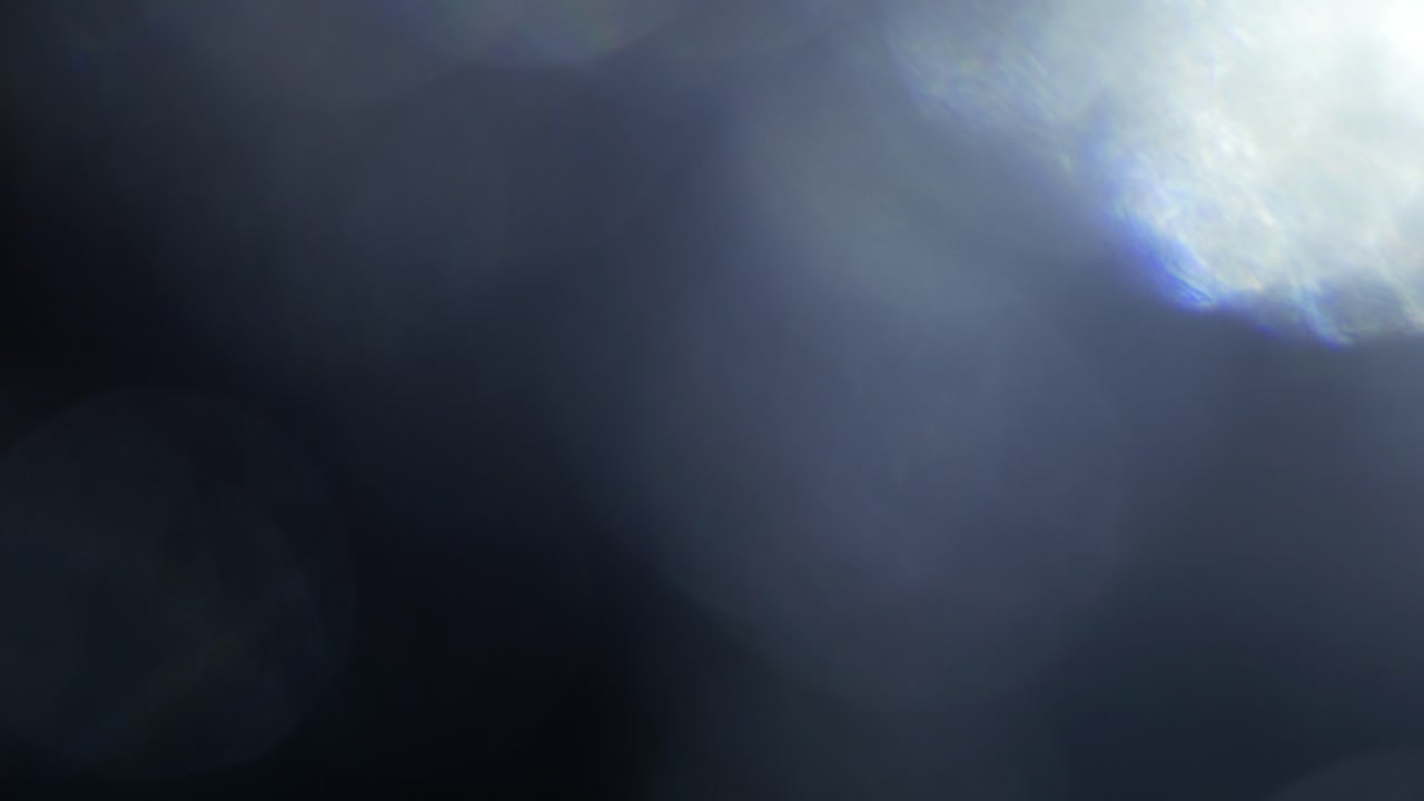 Moving Optical Light Leaks and Lens Flares on Dark Background