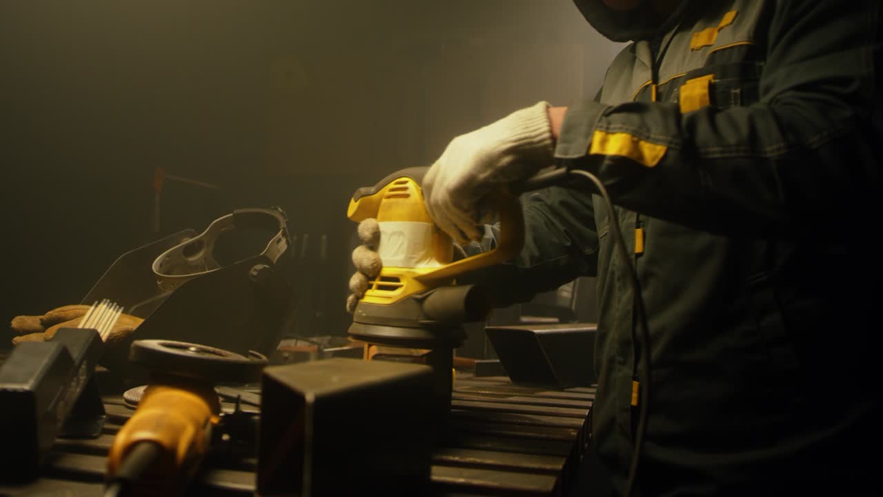 trabajador pulindo metal con un molinillo. interior de una fábrica de la industria pesada con un trabajador usando un molino. molienda eléctrica de tubos de acero en una fábrica. cámara lenta. up close. video 4k. filmado en rojo