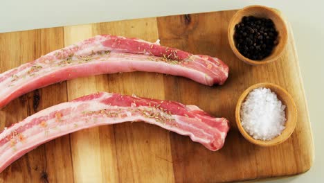 tiras de carne cruda marinadas en tablero de madera