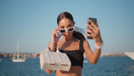 una mujer tomando una selfie junto al agua.