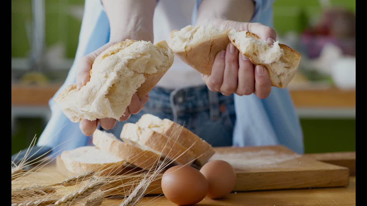 Woman tearing a loaf of bread