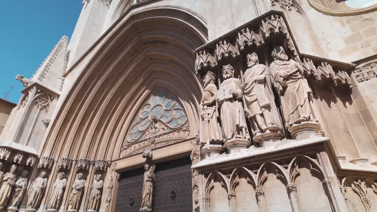 Tarragona Cathedral, stunning Gothic design in historic heart of the city, tilt down across statues to doors