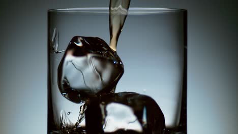 Alcohol-Pouring-Over-Ice-in-Elegant-Cocktail-Glass