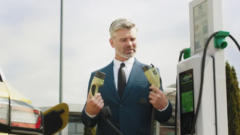 businessman charging an electric vehicle